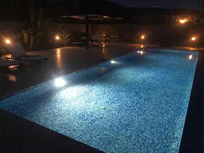 a swimming pool lit up at night with lights at VILLA ASTERAKI private pool, magic sunsets, near Elafonisi in Ãyios FÃ³tios