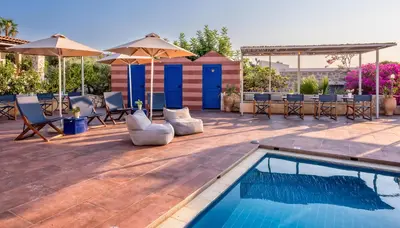 a swimming pool with chairs and umbrellas on a patio at Creta Vitalis in Kalathas