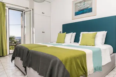 a bedroom with a large bed with a blue headboard at Creta Vitalis in Kalathas