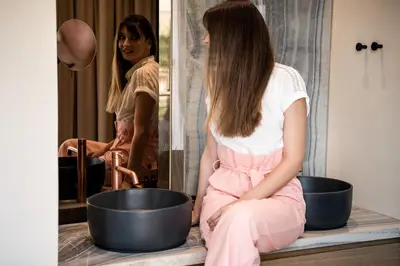 a woman sitting in front of a mirror looking at herself at Divino Suites Chania in Chania Town