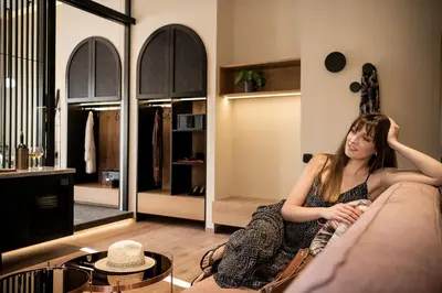 a woman sitting on a couch in a living room at Divino Suites Chania in Chania Town