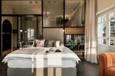 a bedroom with a large bed and a chair at Divino Suites Chania in Chania Town