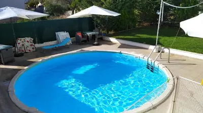 a large blue swimming pool in a backyard at Thanasis Villa in Kounoupidhianá
