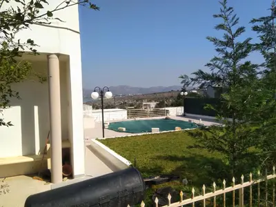 a view from the balcony of a house with a swimming pool at Thanasis Villa in Kounoupidhianá