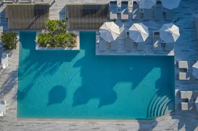 an overhead view of a swimming pool with umbrellas at Atlantica Amalthia Beach Hotel - Adults Only in Agia Marina Nea Kydonias
