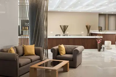 a living room with two couches and a coffee table at Atlantica Amalthia Beach Hotel - Adults Only in Agia Marina Nea Kydonias