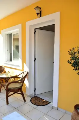an open garage door in a room with a table at Raph's Studios-Apts By The Sea in Agia Marina Nea Kydonias