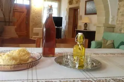 a bottle of alcohol and a plate of food on a table at Wood & Stone in Kissamos