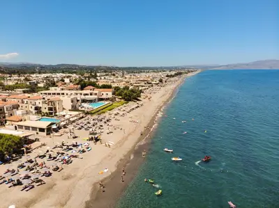 an aerial view of a beach with people in the water at Athina Suites Luxury Suites Near The Sea Platanias in Plataniás