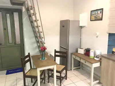 a kitchen with a table and chairs and a refrigerator at Odyssey Apartment in Palaiochóra