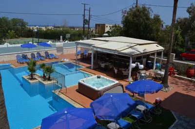 a swimming pool with a hot tub and umbrellas at Sunny Suites in Maleme