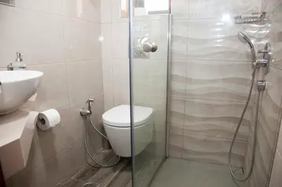 a bathroom with a shower with a toilet and a sink at Sunny Suites in Maleme
