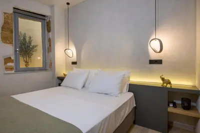 a bedroom with a bed with white pillows and a window at Cretan Berry Sarpaki in Chania Town