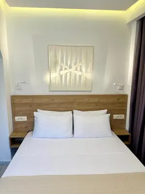 a bed with two white pillows in a room at Cretan Berry Portou in Chania Town