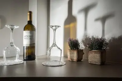 a bottle of wine and two glasses on a table at Cretan Berry Portou in Chania Town