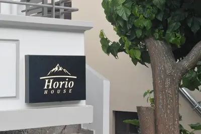 a sign for a honda house next to a tree at Horio House in Límni