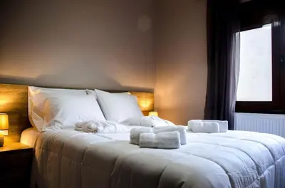 a large white bed with towels on top of it at Horio House in Límni