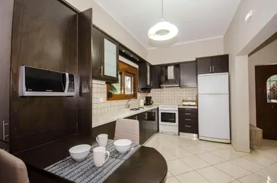 a kitchen with a black table and a white refrigerator at Horio House in Límni