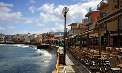 a street with tables and chairs next to the water at Marias Studios in Chania Town
