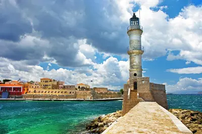 a lighthouse sitting on the edge of the water at Marias Studios in Chania Town