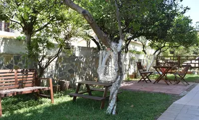 a group of picnic tables and benches under a tree at Modern Apartment with Garden in Kissamos