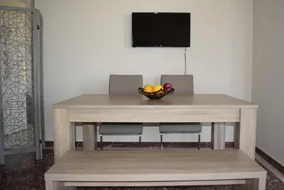 a wooden table with a bowl of fruit on it at Modern Apartment with Garden in Kissamos