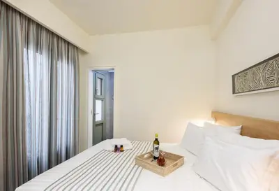 a bedroom with a bed with a bottle of wine at Casa Teresa | Near Sandy Beach in Chania Town