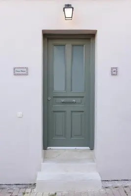 a green door in a white building with a light at Casa Teresa | Near Sandy Beach in Chania Town