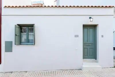 a white building with a green door and windows at Casa Teresa | Near Sandy Beach in Chania Town