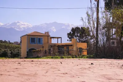a house sitting on top of a dirt road at Calma Seaside Villa in Kalyves