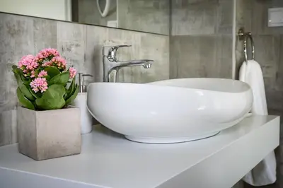 a bathroom with a sink and flowers on a counter at Platanias Villa Mirsini in Plataniás