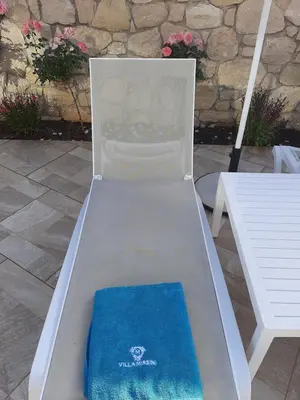 a chair with a blue blanket on it next to a bench at Platanias Villa Mirsini in Plataniás