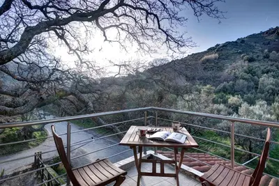 a table and chairs on a balcony with a view at Antartisa B&B in Límni
