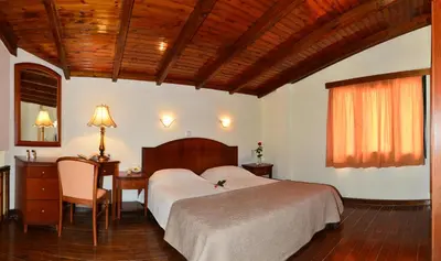 a bedroom with a bed and a desk and a table at Antilia Apartments in Tavronitis