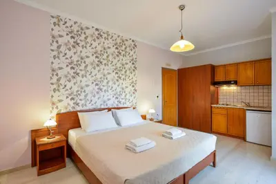 a bedroom with a bed with two towels on it at Poseidon Apartments in Kato Daratso