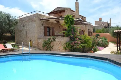 a house with a swimming pool in front of a building at Drys Villas in Xirokámbion