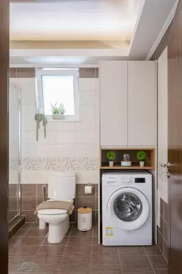 a bathroom with a toilet and a washing machine at NeSo - Peter's Flat steps to Beach with Great Views in Kolymvari
