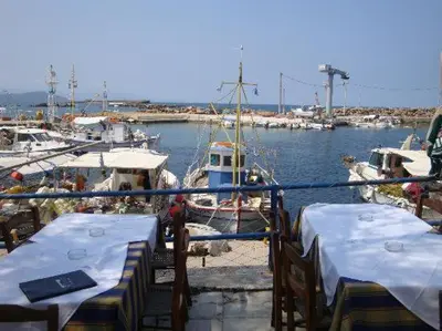 a marina with tables and boats in the water at Maria's house in front of the beach in Chania Town