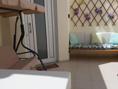 a room with a bed and a bench with pillows at Maria's house in front of the beach in Chania Town