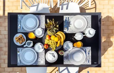 a table with blue and white plates and fruit on it at Sunny Luxury Apartment in Chania Town