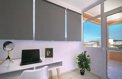 a laptop on a desk in a room with a window at Sunny Luxury Apartment in Chania Town