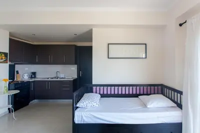 a small bedroom with a bed and a kitchen at Paleochora Houses N2 in Palaiochóra