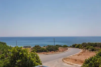 an empty road with the ocean in the background at Paleochora Houses N2 in Palaiochóra