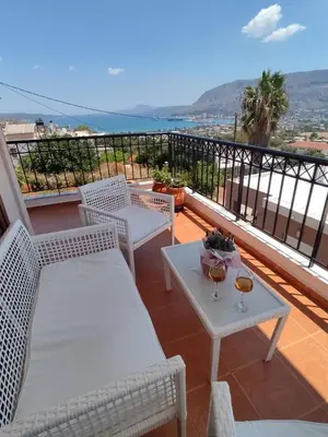 a balcony with two white chairs and a table at Chrisas Apartment Chania in Chania Town