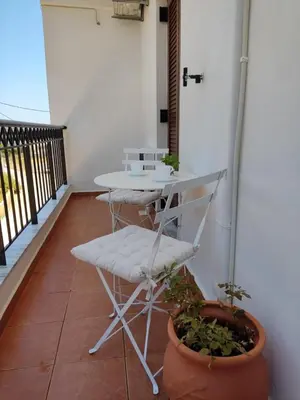 a balcony with a table and a chair on a patio at Chrisas Apartment Chania in Chania Town