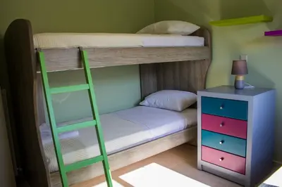 a bunk bed with a ladder and a dresser in a room at Lydia's Apartment in Stílos