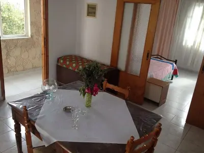 a dining room table with a vase of flowers on it at House with Sea View close to Platanias in Vrísai