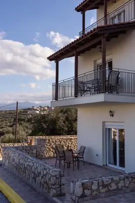 a house with chairs and a balcony with a table at Like Home in Agia Marina Nea Kydonias