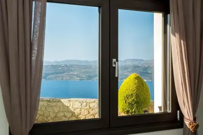 a window with a view of the ocean at Margarita Apt - Amazing Relaxing View in Megála Khoráfia