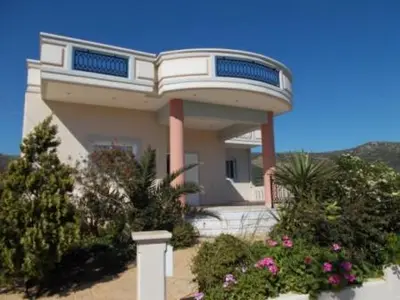 a house with a round top with flowers in front of it at Panoramic Balos Sea View House in Kissamos